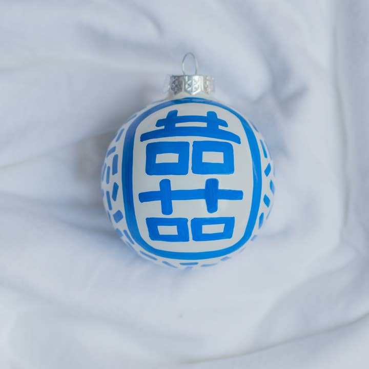 Hand-painted ceramic ornament featuring a red double happiness symbol on a white background.