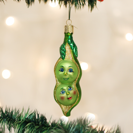Mouth-blown glass ornament shaped like two peas in a pod with silver accents and hand-applied glitter finish.