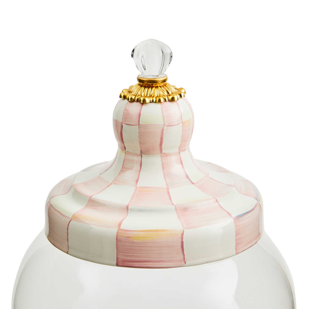 Close-up of a pink and white hand-painted checkered lid with a gold base and glass knob.