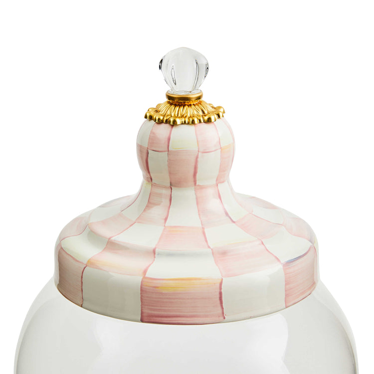 Close-up of a pink and white hand-painted checkered lid with a gold base and glass knob.