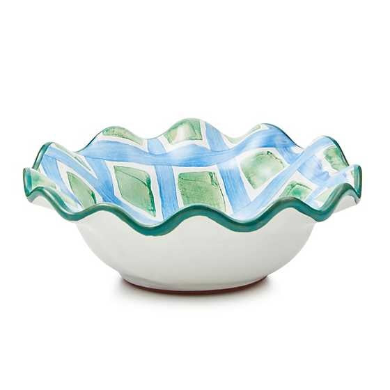 Hand-painted majolica ceramic bowl with green fluted rim, diamond dot pattern on white background.