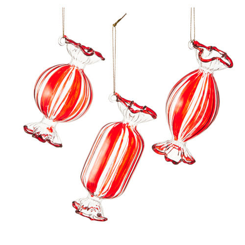 Glass peppermint candy ornament with red swirls on white background