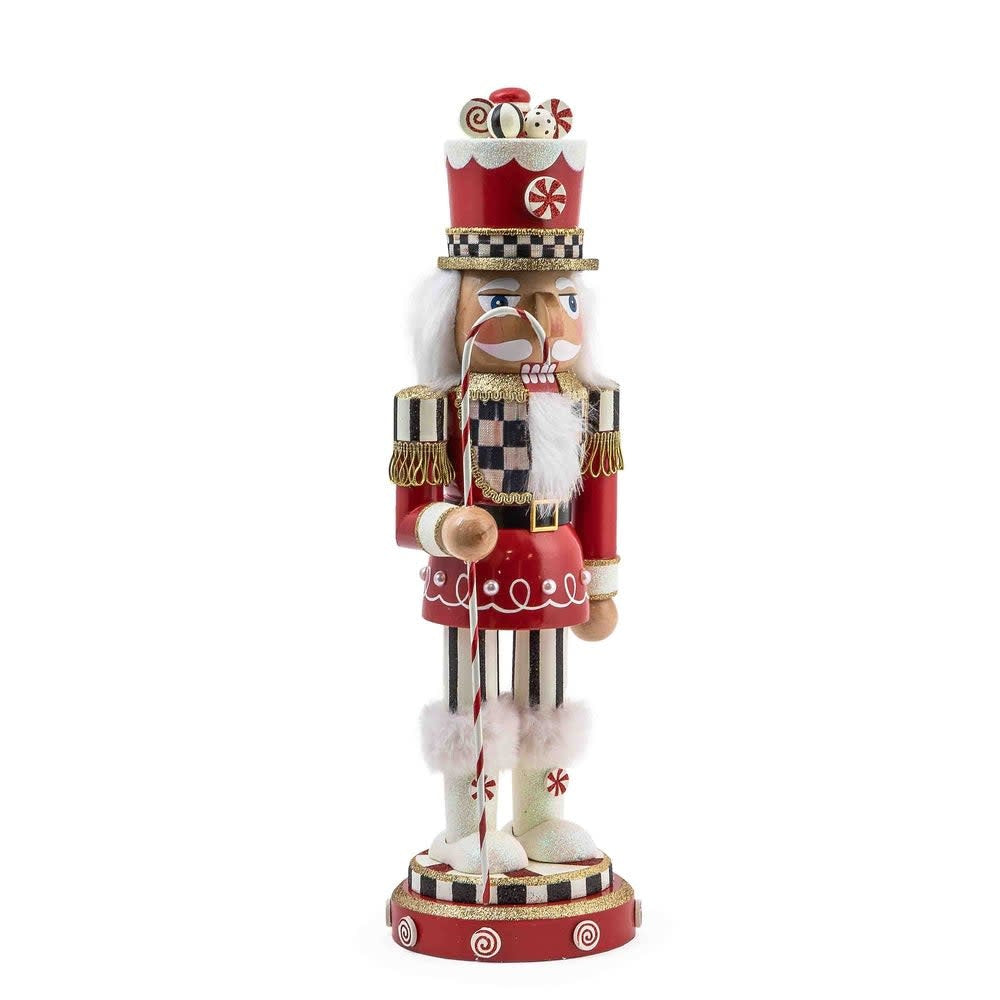 Hand-painted wooden nutcracker in red Courtly Check fabric with peppermint decorations and candy cane.