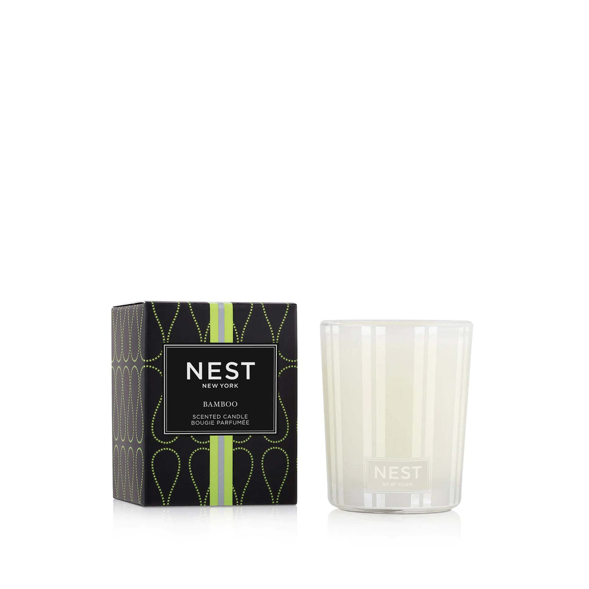 Nest New York Bamboo scented candle in a frosted glass vessel next to its decorative green box.