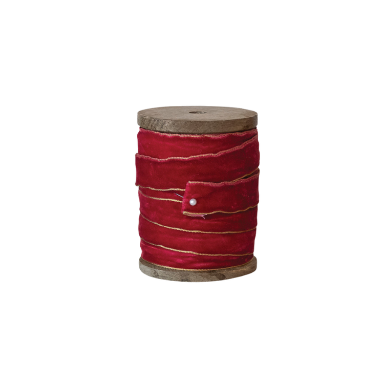 Red velvet ribbon with metallic gold edges wound on a mango wood spool.