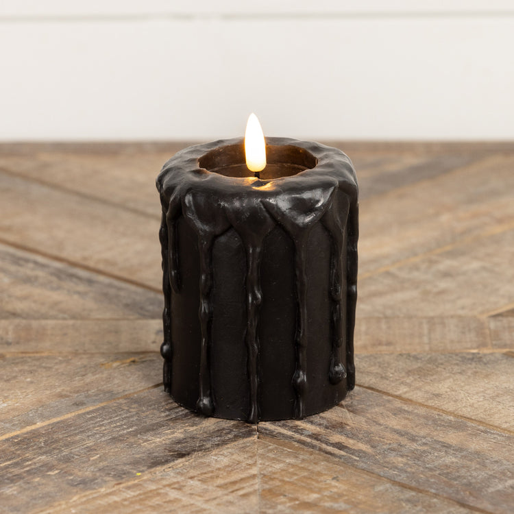 Black plastic pillar candle with realistic flickering flame effect.