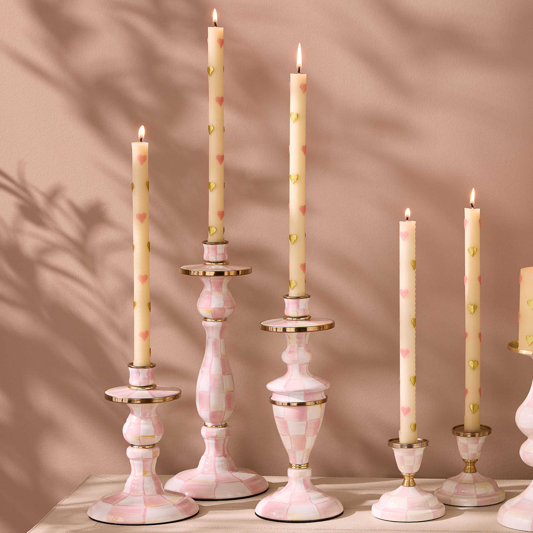 Hand-painted pink and white checkered candlesticks with brass accents and heart-patterned candles.