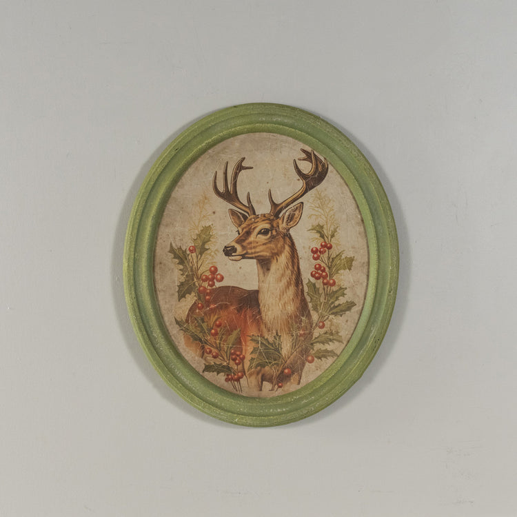 Oval framed print on glass featuring a holiday stag silhouette with natural wood frame.