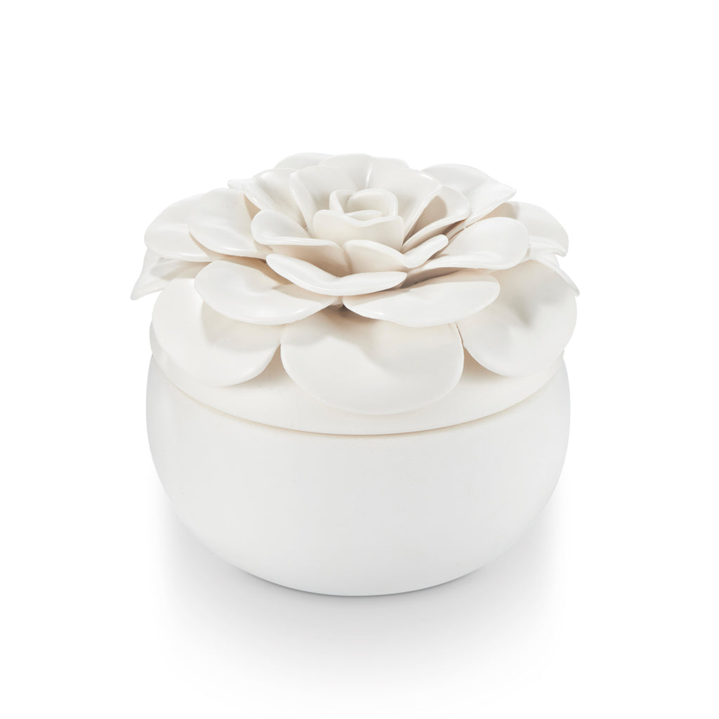 Ceramic flower candle with three wicks in a petal-shaped vessel.