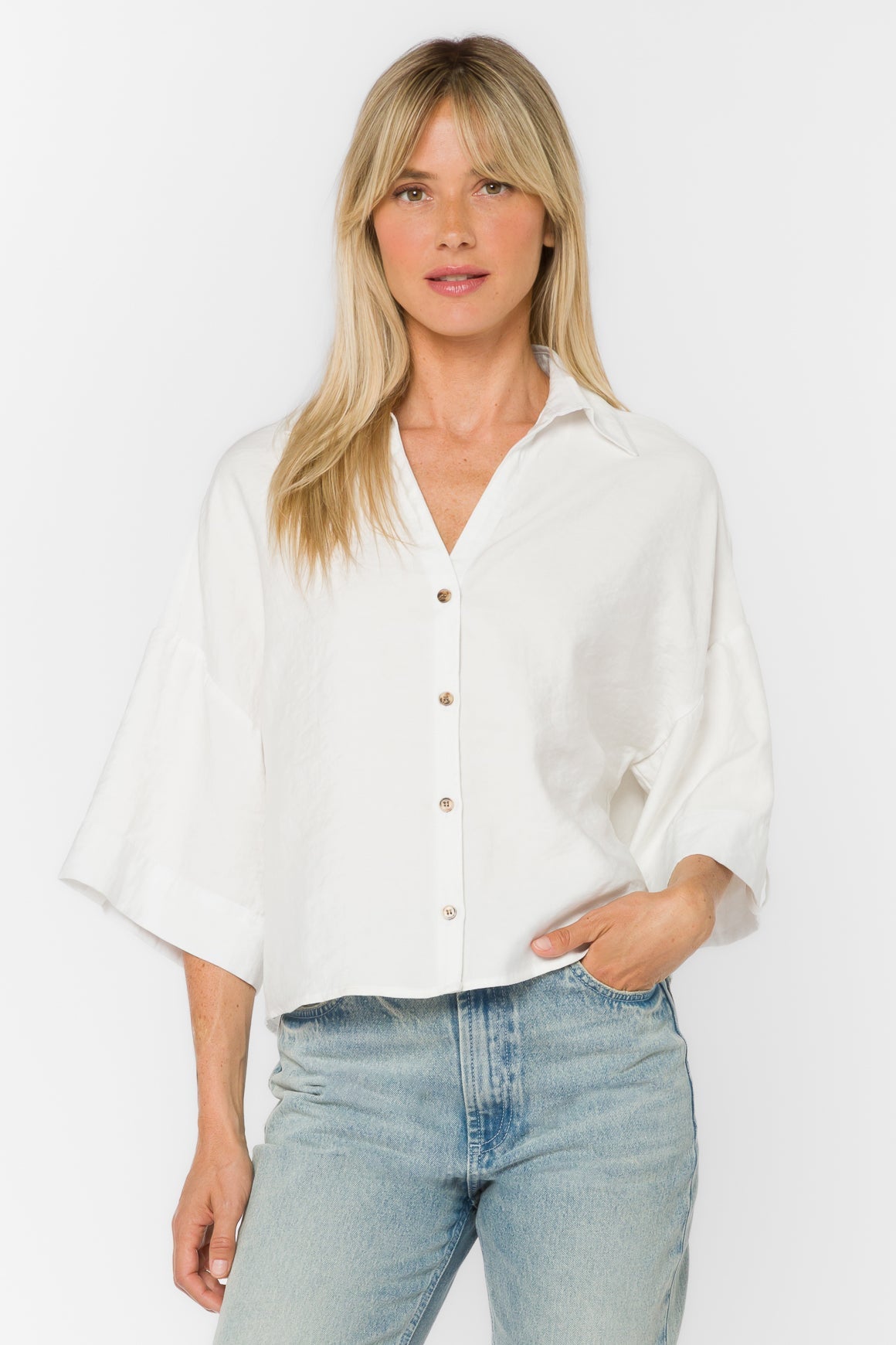 Woman wearing a white Minx Shirt with a collared Y-neckline and elbow-length sleeves.