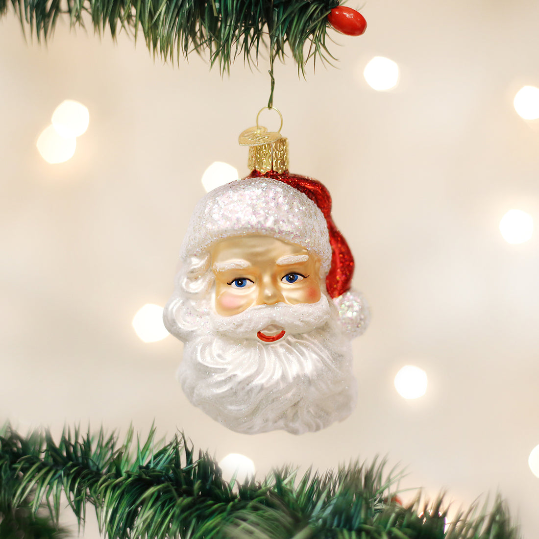 Mid Century Santa Head glass ornament with a white glittered beard and red hat on a Christmas tree.