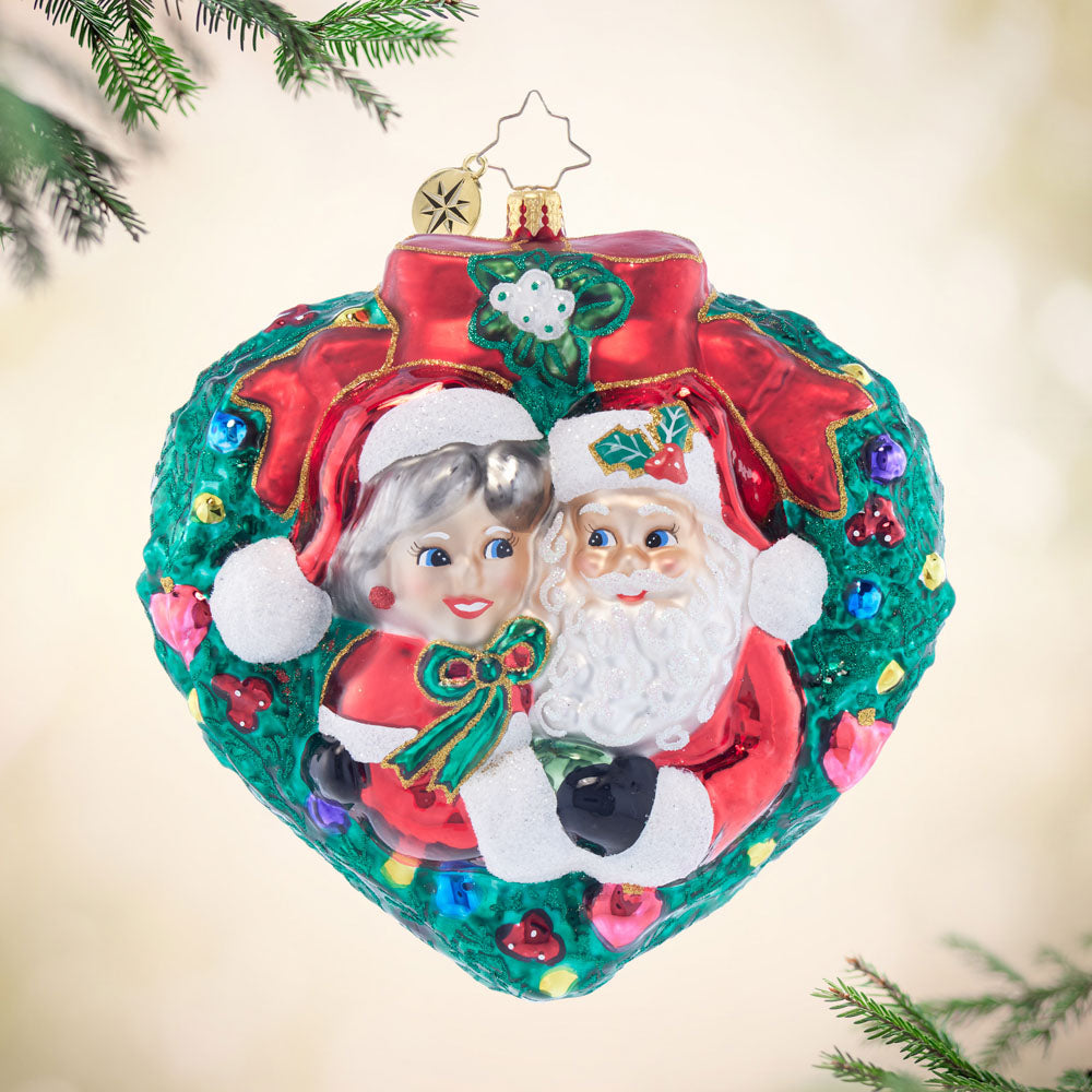 Mr. & Mrs. Claus Mistletoe Moment ornament with red suit figures and green mistletoe design.