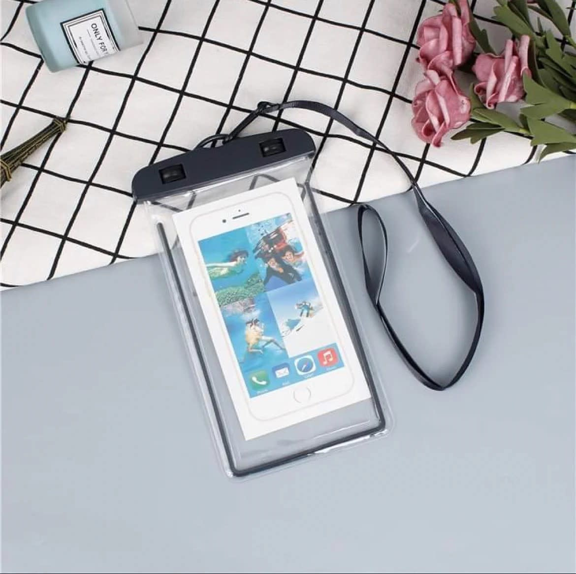 Transparent waterproof phone dry pouch with black zipper closure and attached neck lanyard.