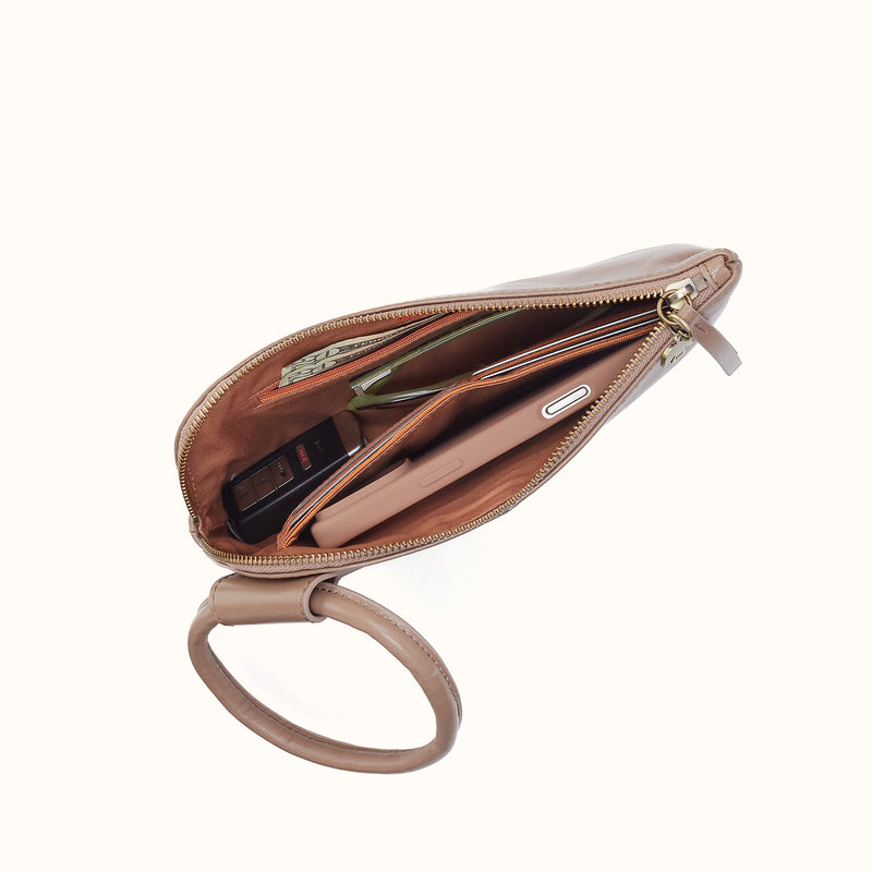 Open Woodsmoke leather Sable wristlet showing interior pockets with phone, keys, and cash.