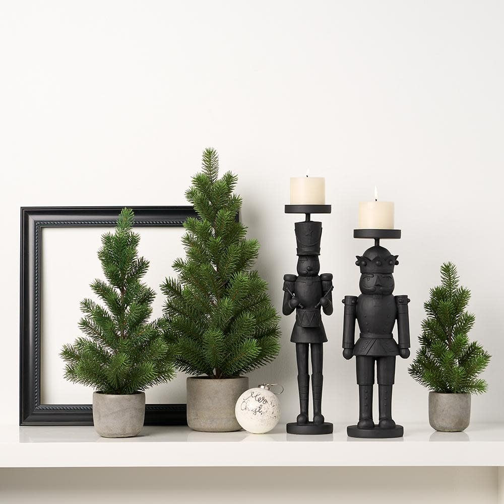 Green artificial pine tree in a cement pot with plastic foam materials.