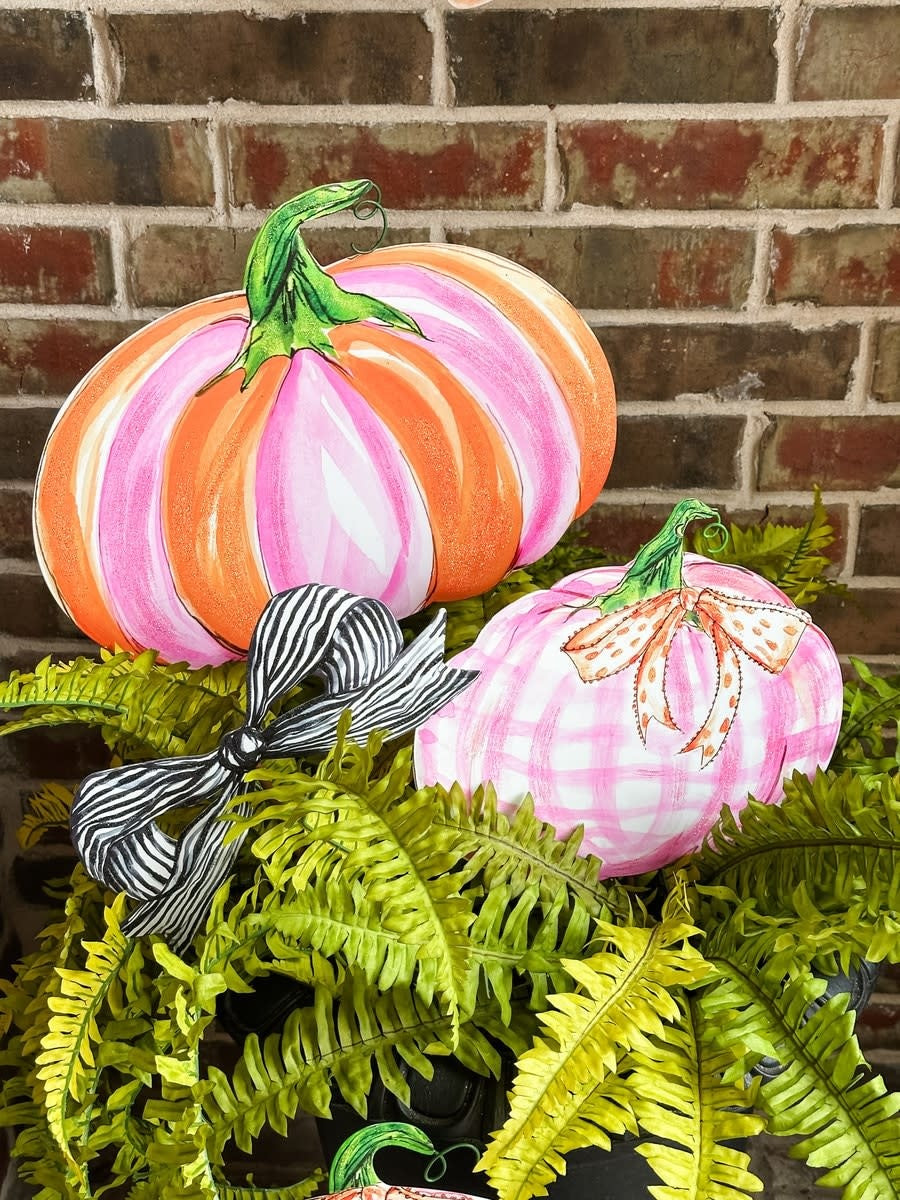 Metal pumpkin decoration in pink and orange with a festive seasonal silhouette.