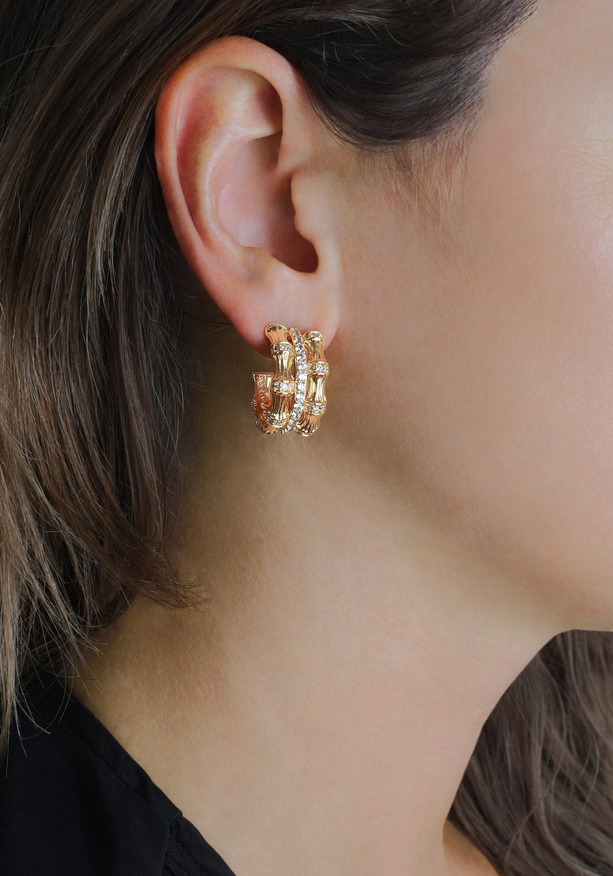 A person wearing a Bamboo Stacked Hoop Earring in 18K gold-plated brass with crystal pavé.