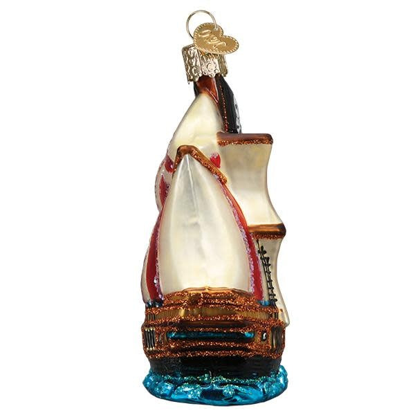Glass pirate ship ornament with full sails, Jolly Roger flag, hand-painted silver accents, and glitter finish.