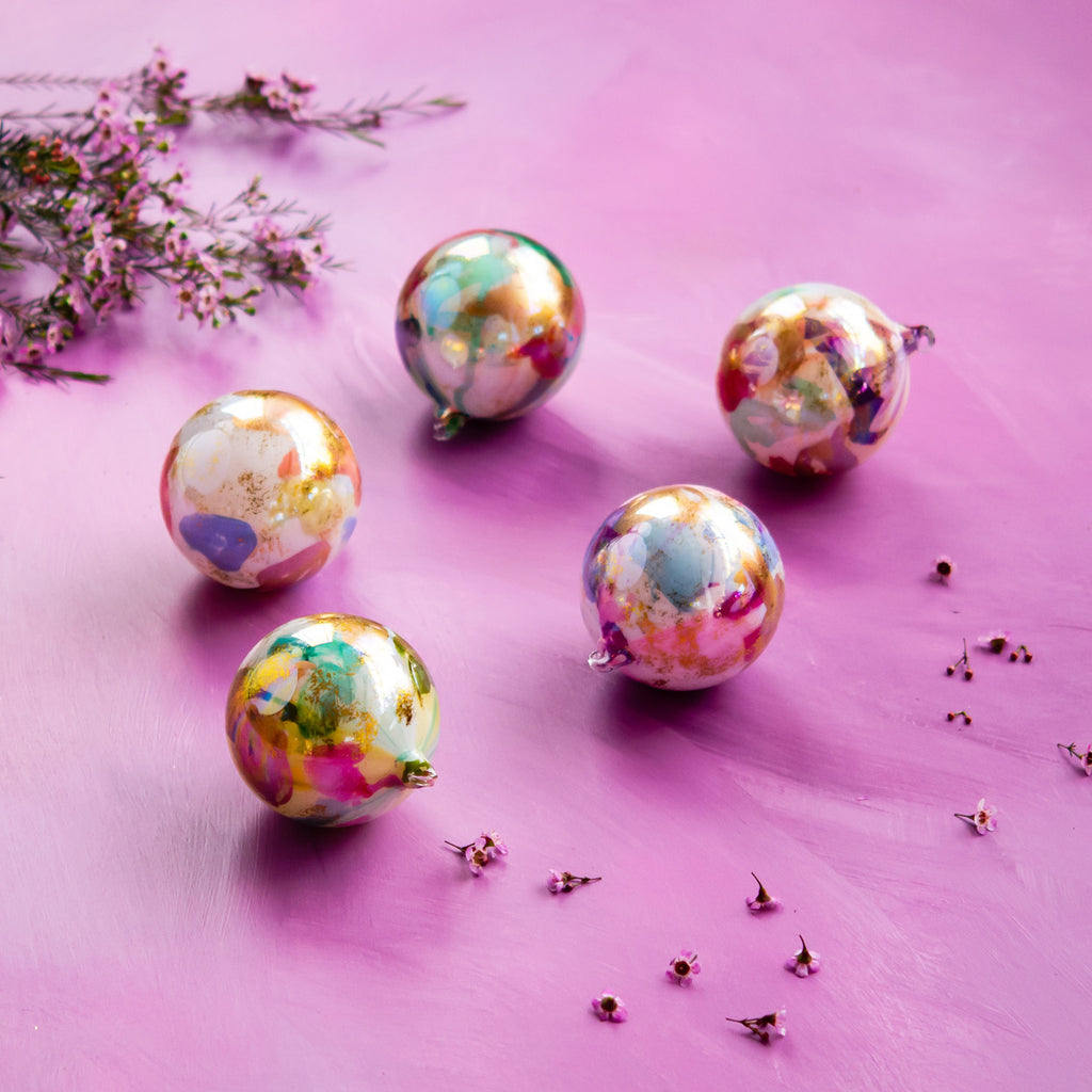 Hand-blown glass ball ornament in Color Couture with a smooth spherical silhouette.