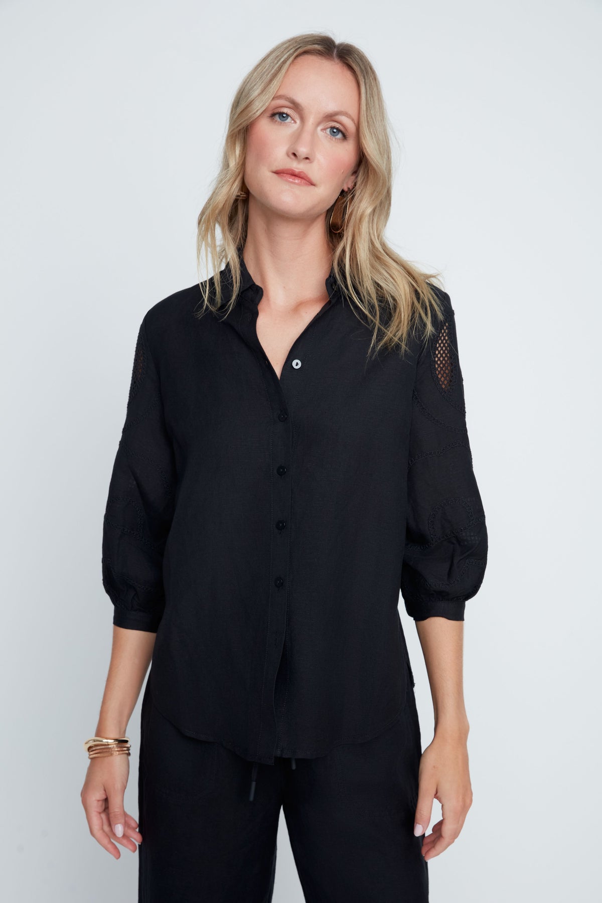 Hannah Woven Blouse in soft neutral tone with relaxed silhouette, button-front closure, subtle textured sleeves, and sheer panel accents.