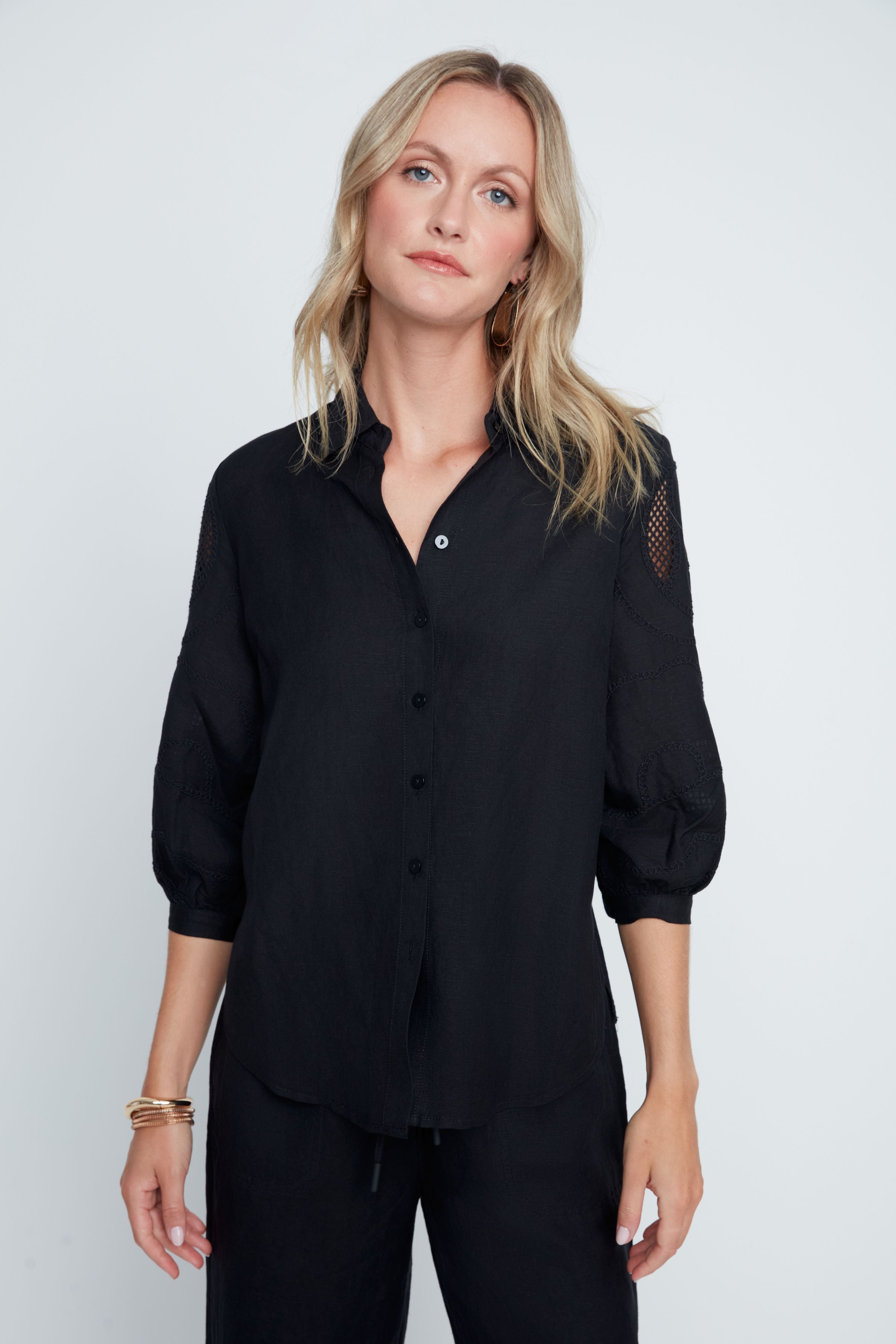 Hannah Woven Blouse in soft neutral tone with relaxed silhouette, button-front closure, subtle textured sleeves, and sheer panel accents.