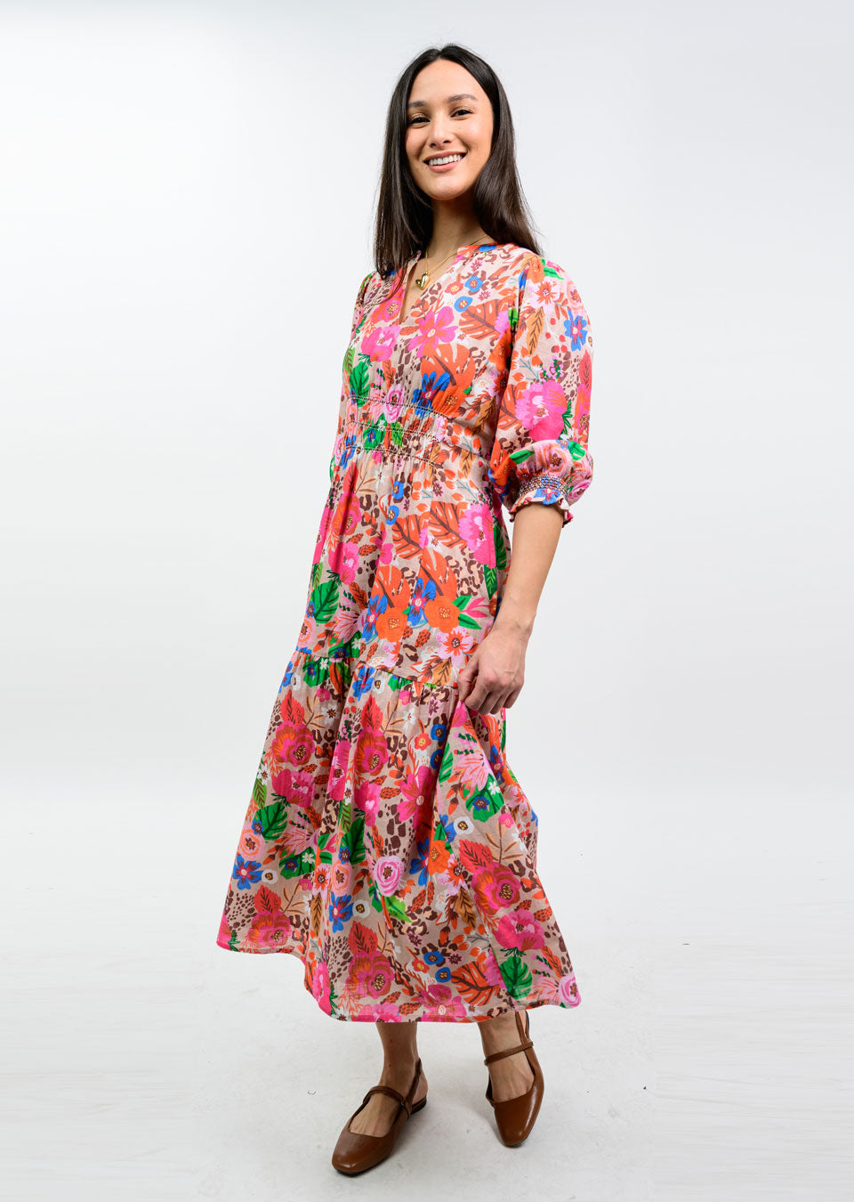 Woman wearing the Elise Floral Smocked Tiered Maxi Dress with 3/4 puff sleeves and brown flats.