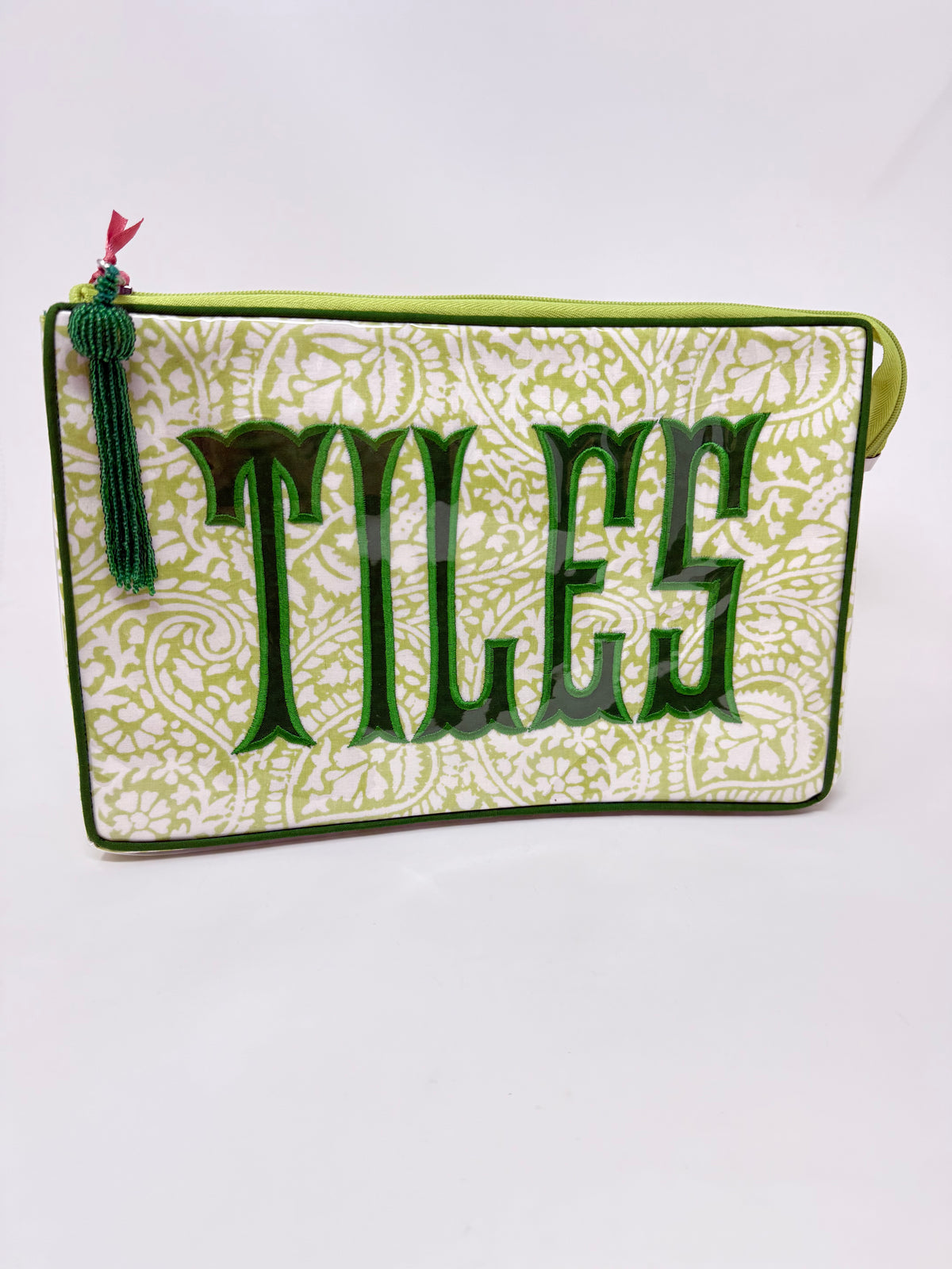 Lime green paisley cosmetic bag with dark green 'TILES' applique and a decorative tassel.