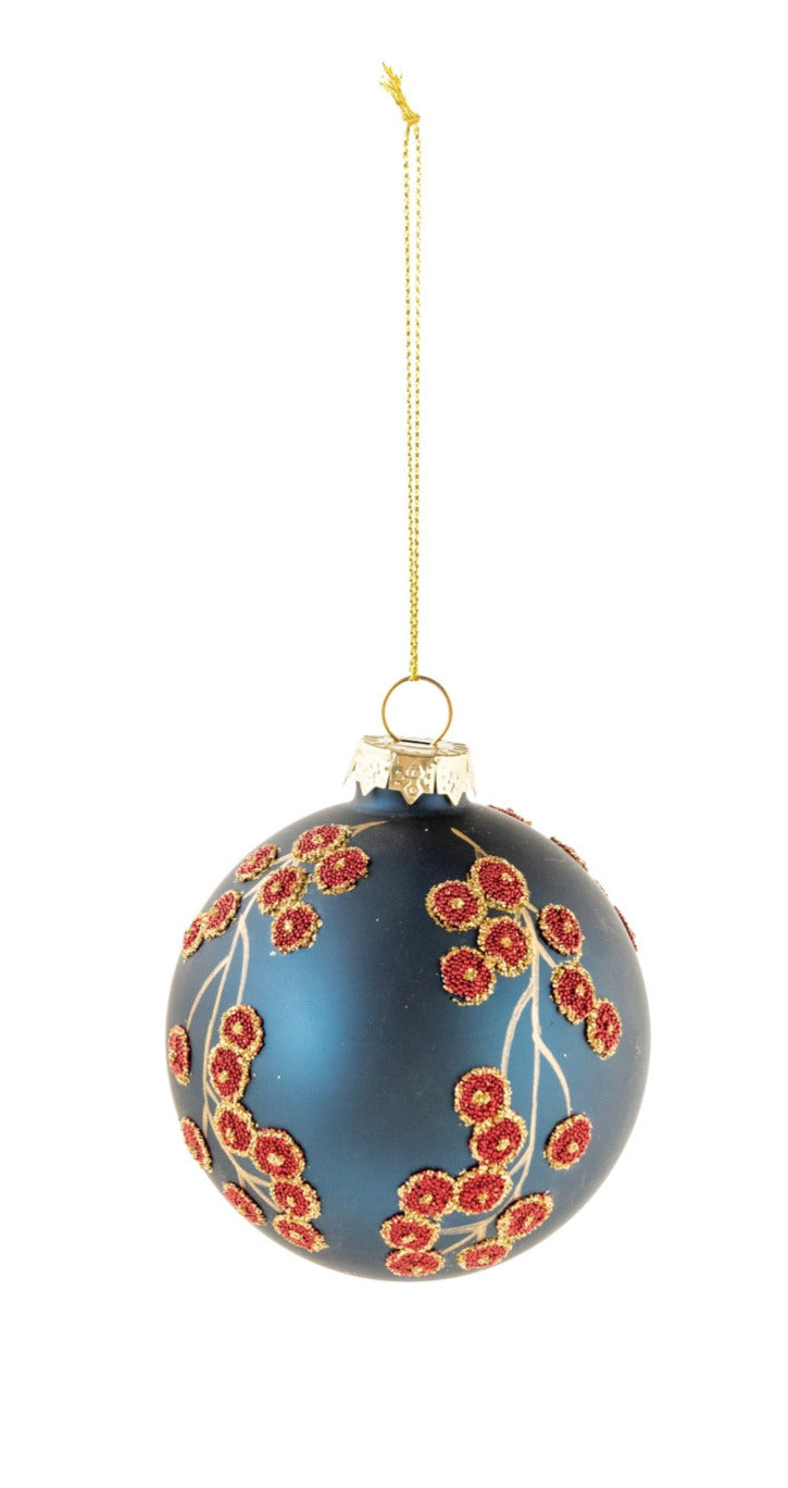 Navy blue glass ball ornament with red beaded botanical motifs and gold accents.