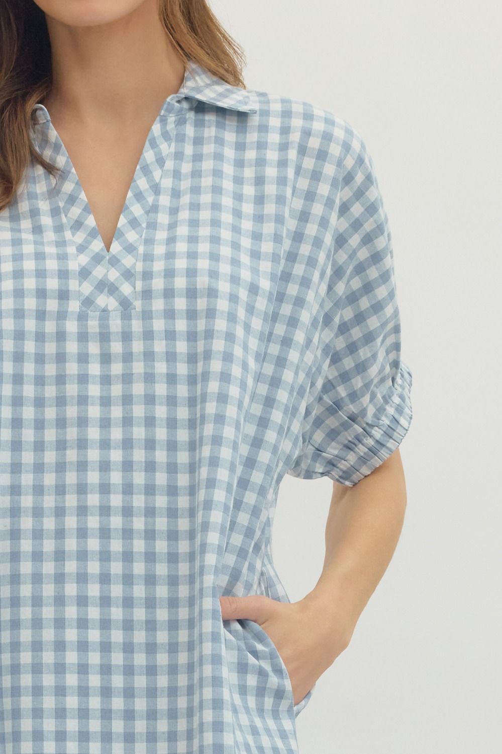 Close-up of the Naomi Gingham Mini Dress in blue and white with a V-neck and short elasticated sleeves