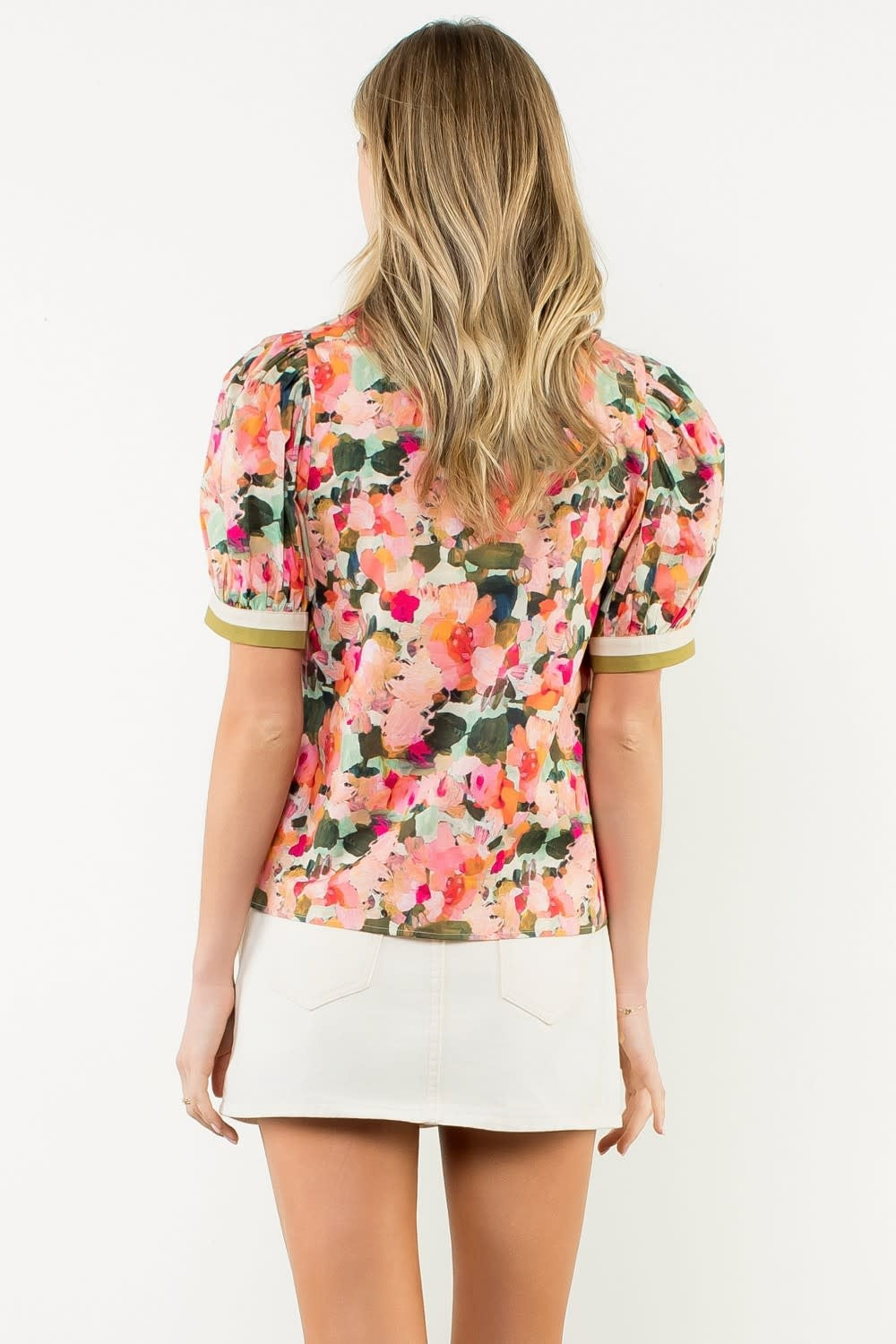Back view of a white cotton pleated collar puff sleeve top with voluminous sleeves.