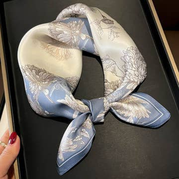 Blue and white 100% mulberry silk square scarf with floral print tied in a knot.