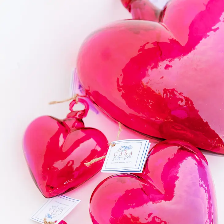 Hand-blown glass heart pendant in translucent amber with smooth organic curves.