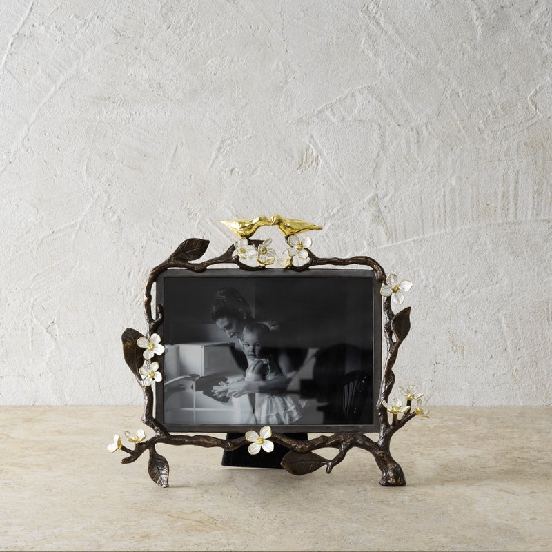 Oxidized goldtone frame with white enamel finish holding a 5x7 photo.