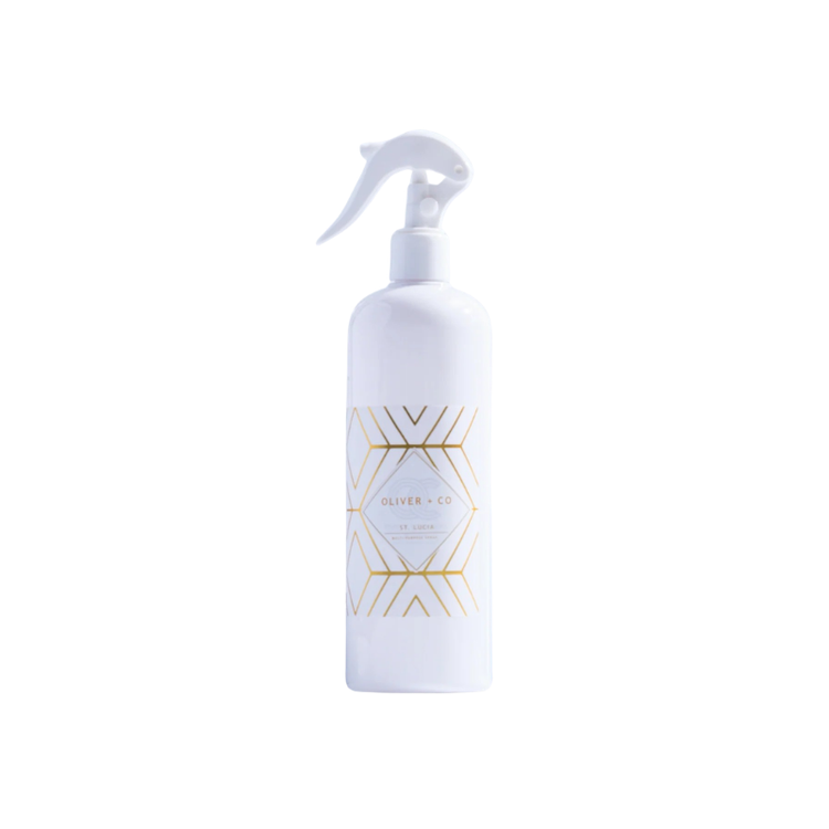 White spray bottle of Oliver + Co Multi-Purpose Cleaner with gold geometric design on the label.