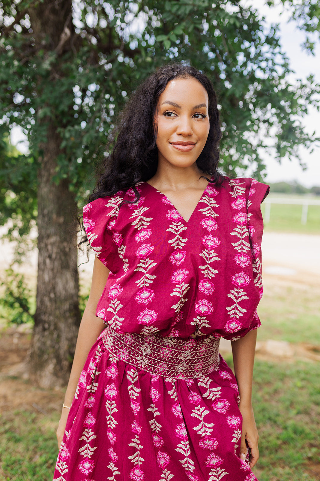Woman wearing the Jane Bubble Top in wine with a floral print, v-neckline, and elastic bubble hem.
