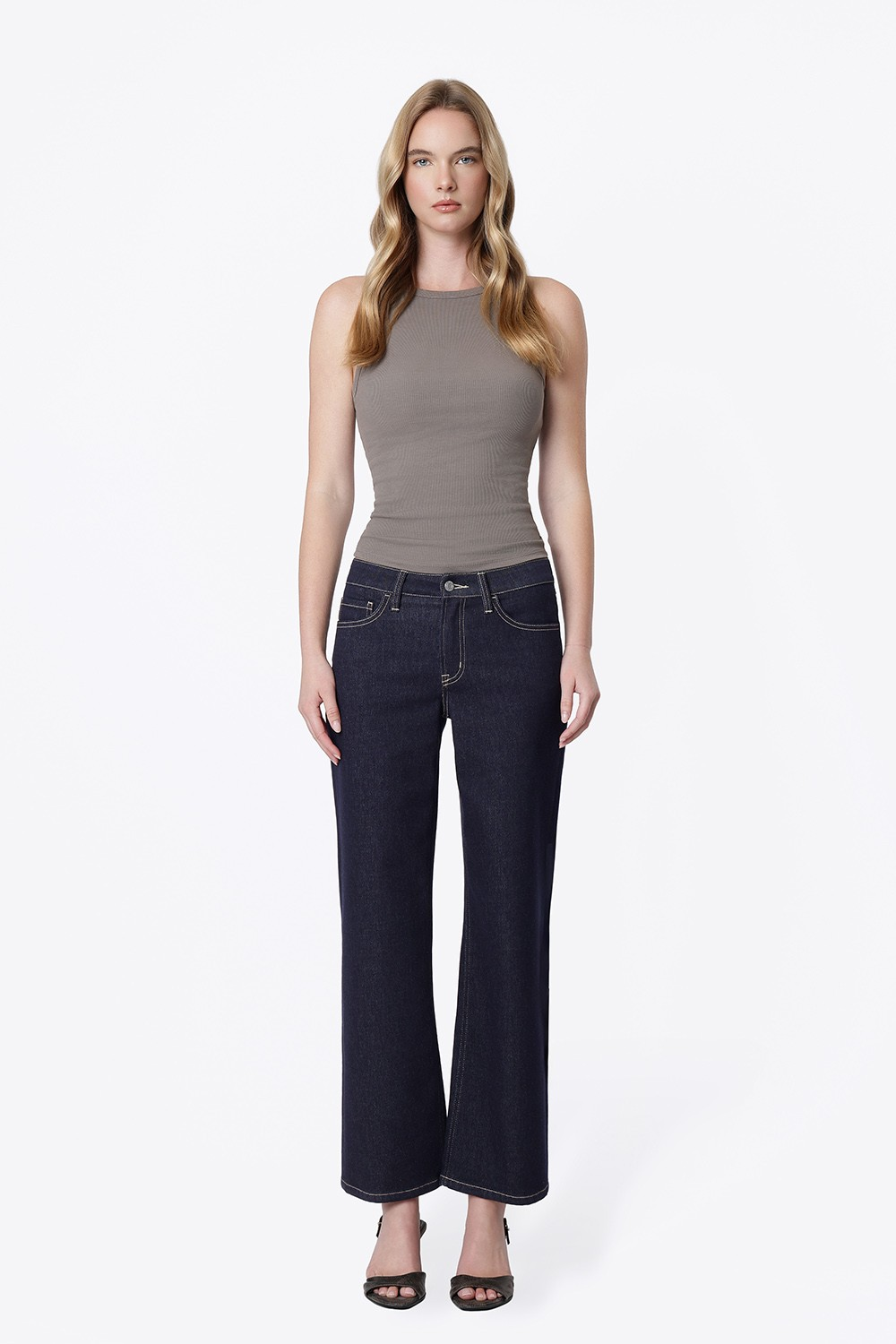 Woman wearing Alexa mid rise dark wash slim wide jeans with a grey ribbed tank top.