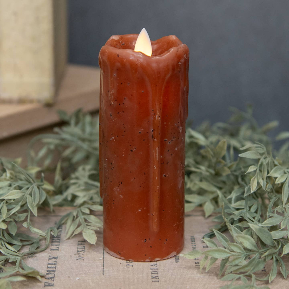 Moving Flame Bronze Pillar Candle with a realistic flickering LED flame on a rustic surface.