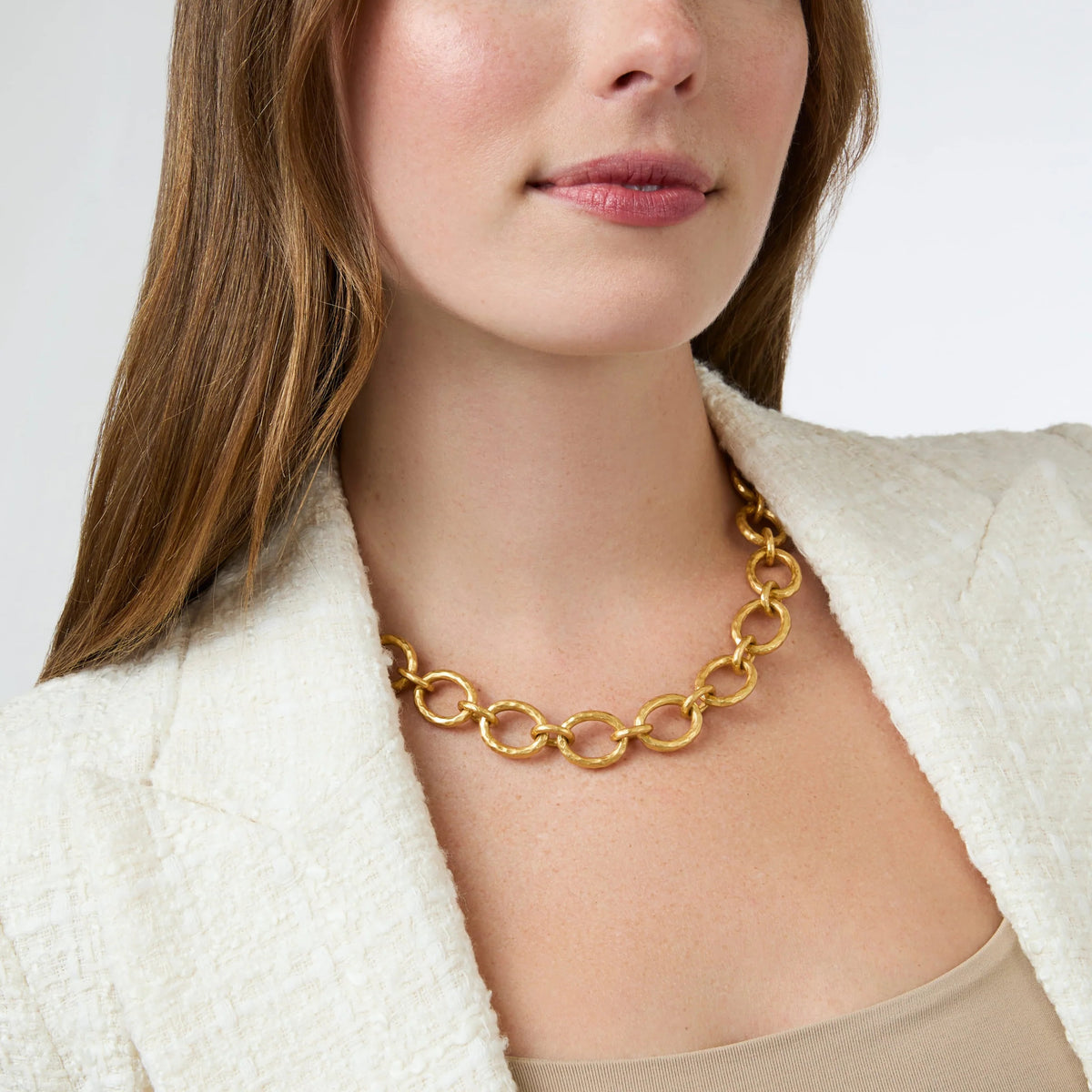 Woman wearing a Catalina Demi Link Pearl Necklace with hammered golden links and a white blazer.