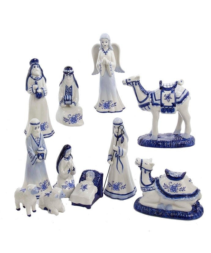 White porcelain nativity set with Delft blue designs featuring Baby Jesus, Mary, Joseph, Wise Men, an angel, camels, and sheep.