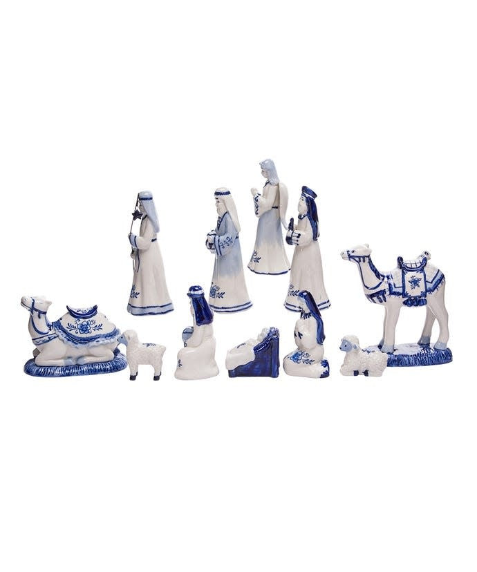 White porcelain nativity set with Delft blue designs featuring Baby Jesus, Mary, Joseph, Wise Men, an angel, camels, and sheep in a magnetic display.