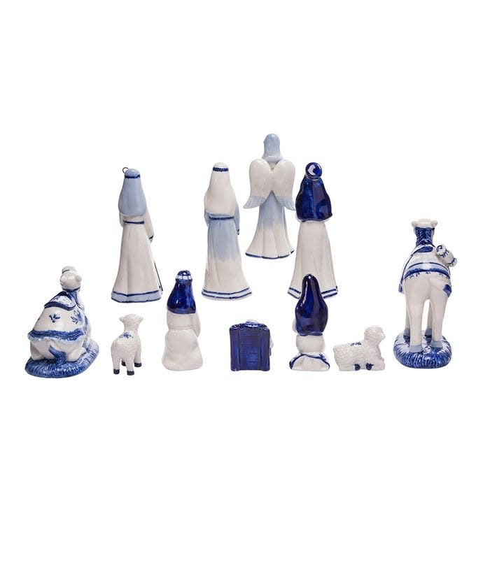 White porcelain nativity set with Delft blue designs featuring Baby Jesus, Mary, Joseph, Wise Men, an angel, camels, and sheep.