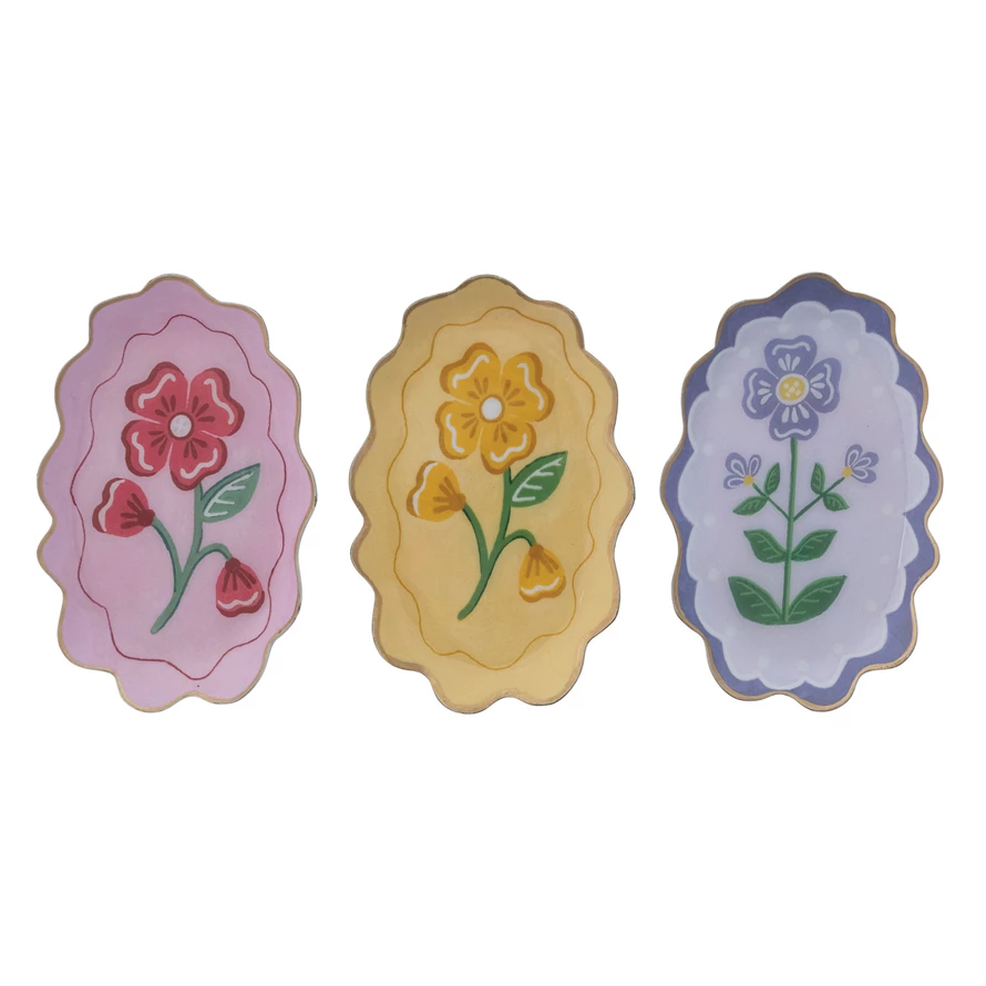 Enameled metal scalloped tray with a flower motif and gold edge trim.
