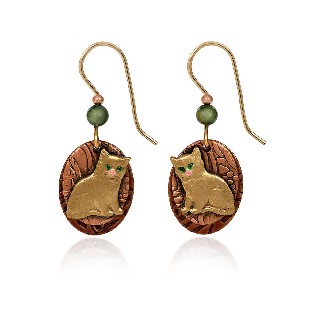 Mixed-metal oval earrings with a textured backdrop, beaded accents, and an artisan-soldered layered kitty charm in gold tone.
