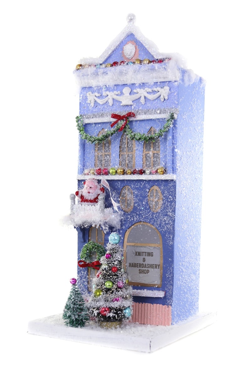 Blue cardboard Christmas shop decoration with Santa, trees, and Knitting & Haberdashery signage.