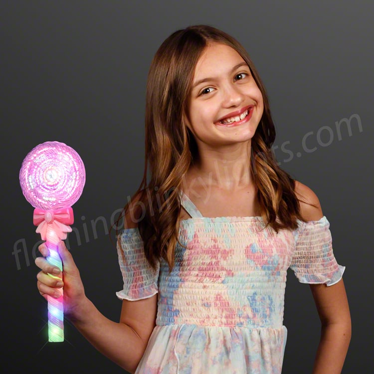Girl holding a deluxe light up spinning lollipop wand with a pink top and multicolor LED handle.