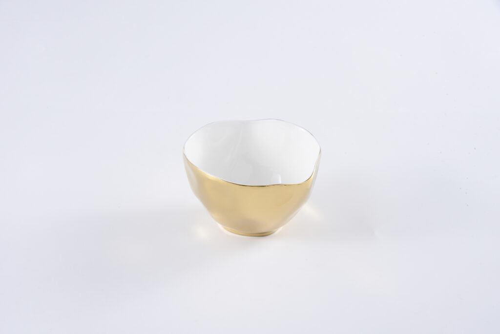 Small white porcelain bowl with a gold titanium exterior and an irregular rim.
