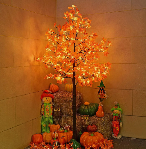 Lighted fall maple tree with warm white LEDs surrounded by pumpkins and autumn decor.