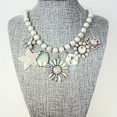 Fashion pearl necklace with seven charms ranging from one to one point seven five inches in diameter