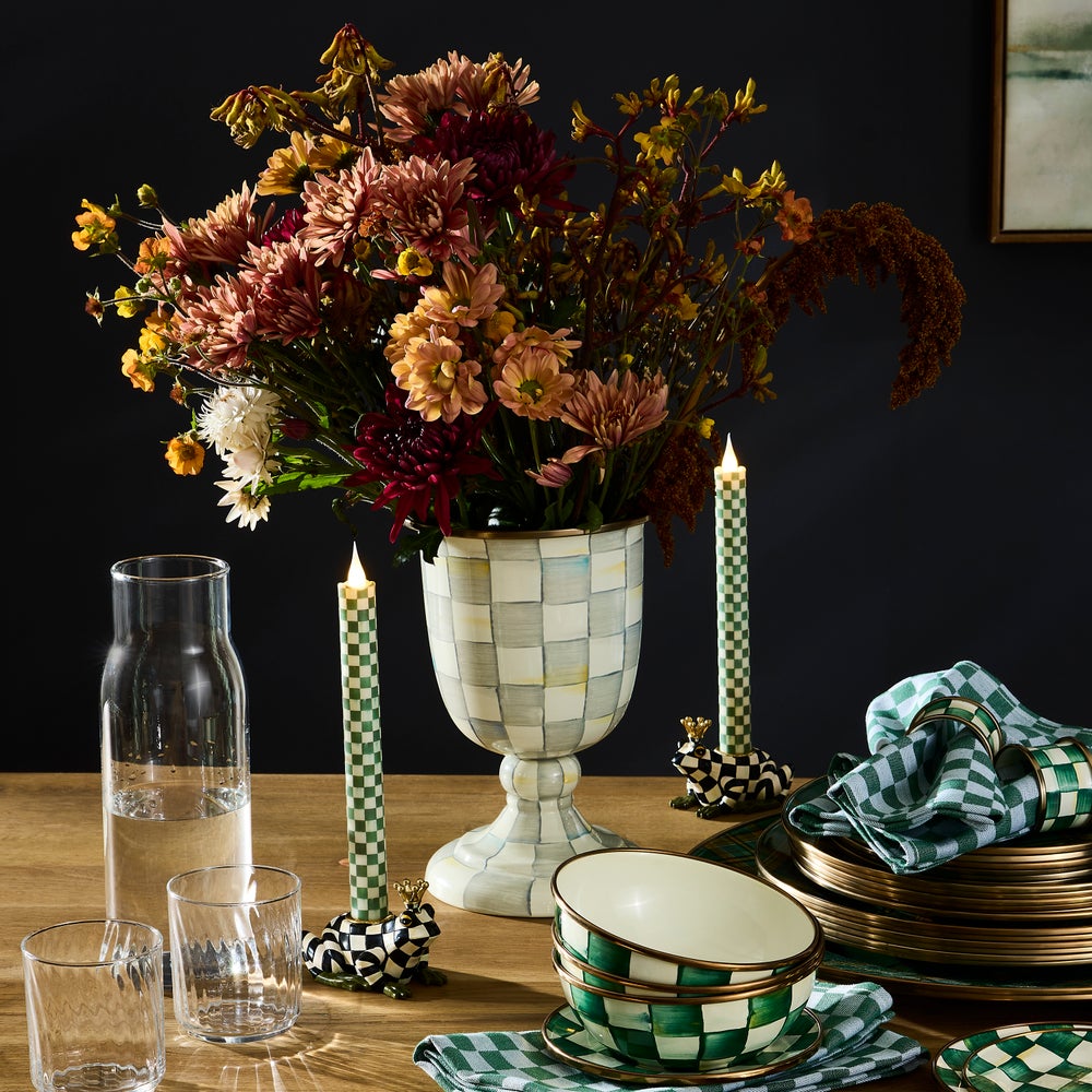 Hand-painted Check Pedestal Vase holding a large autumn floral arrangement on a set dinner table.