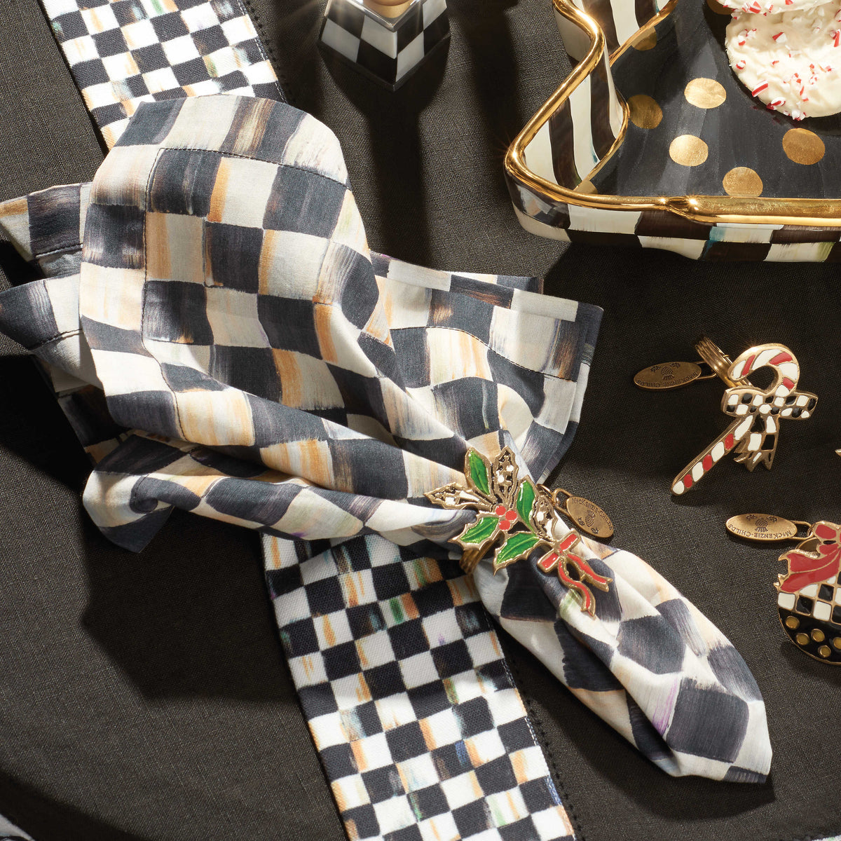 Courtly Check Cotton Napkin in a festive holiday napkin ring on a black tablecloth.